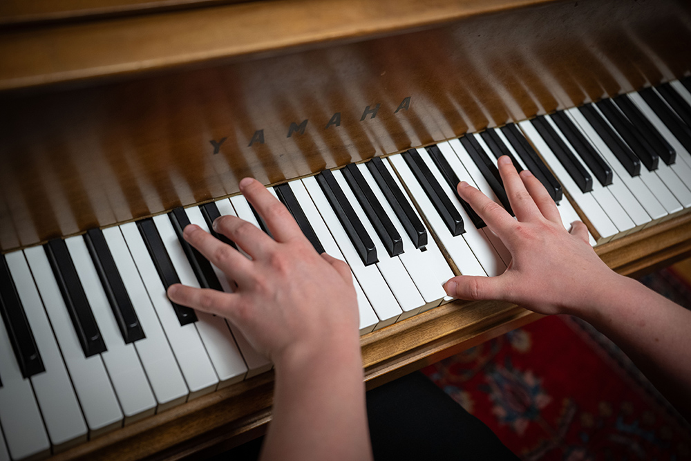 A closeup of Kel Raphael's hands as they play piano