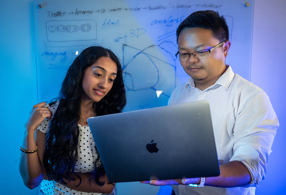 Aarushi Rao and Dr. Zhang  analyze data on a laptop