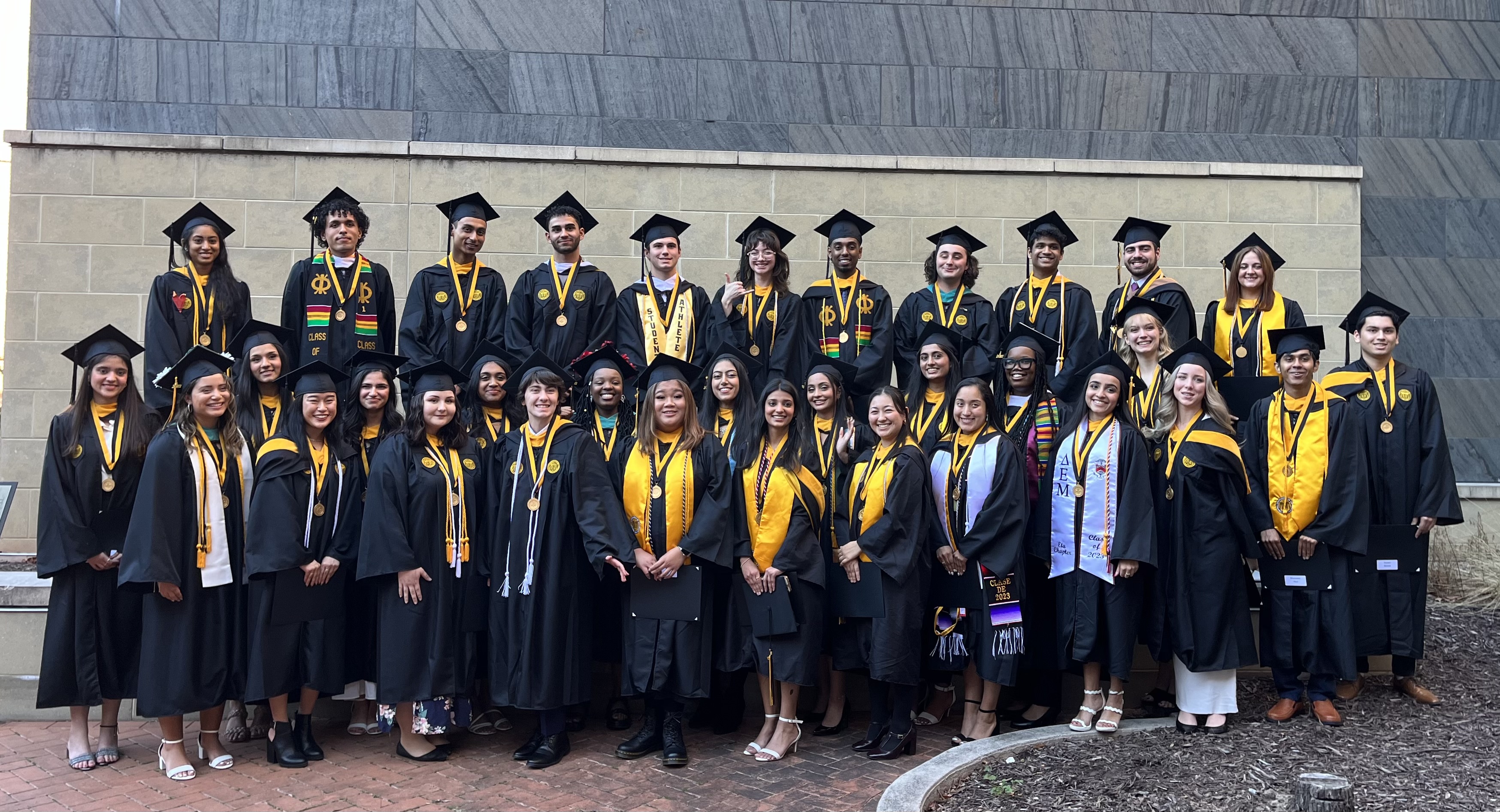 The Honors College class of fall 2023 posing for a photo wearing full regalia