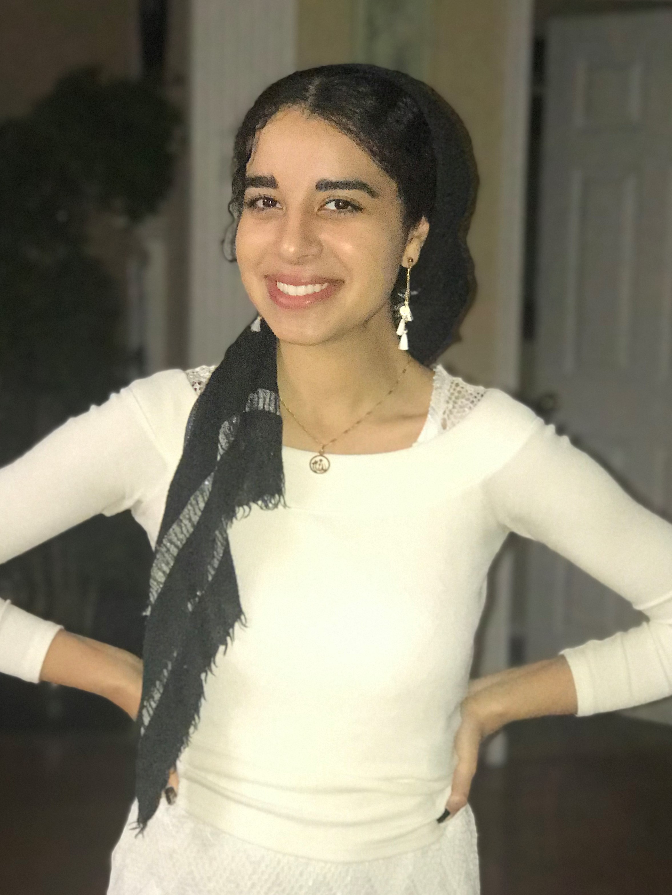 Maryum Elnasseh wearing a white shirt with earrings
