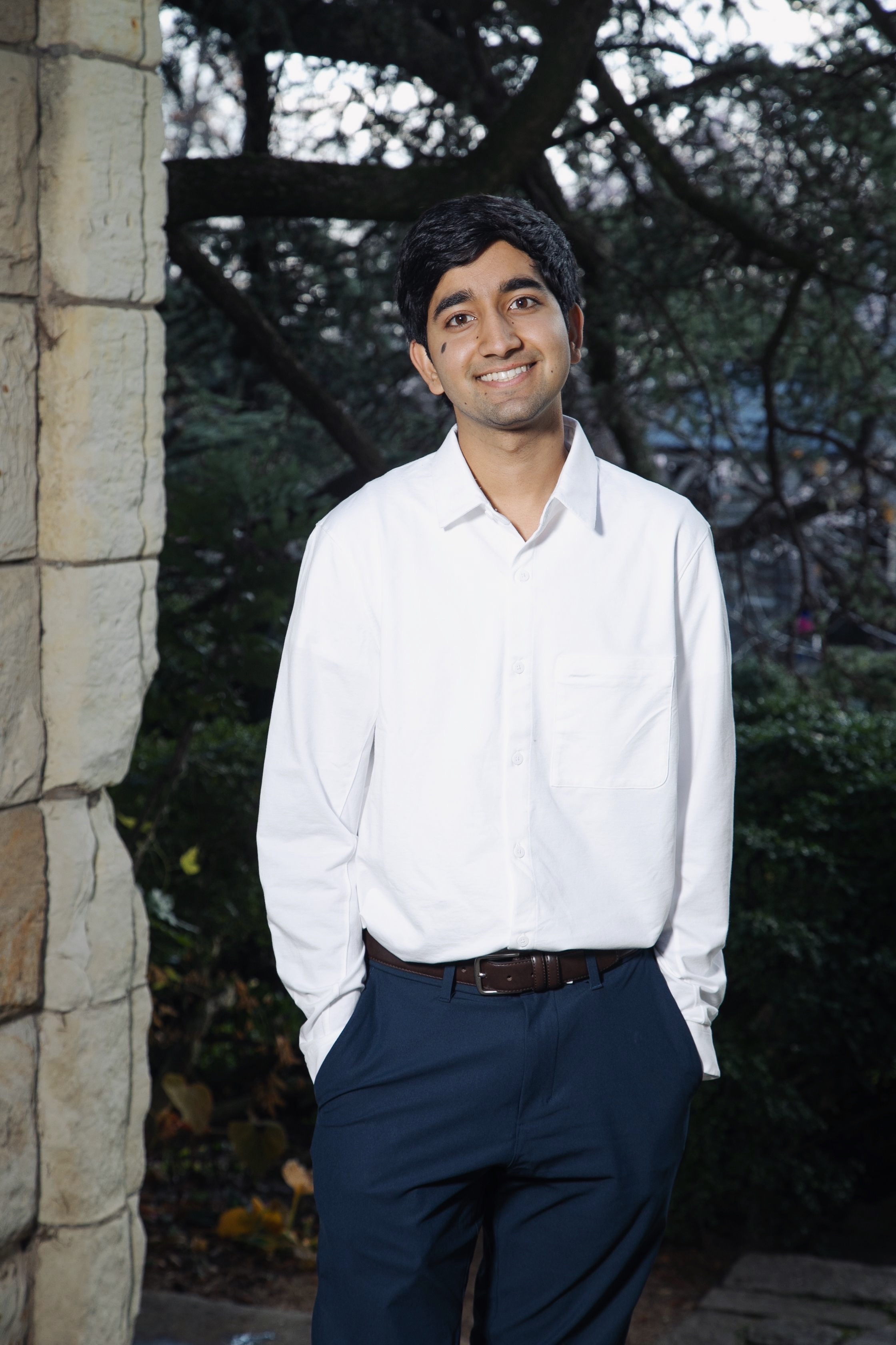 A young man wearing a white dress shirt and black slacks