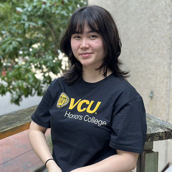 Madelaine Dye wearing a black and gold Honors College shirt