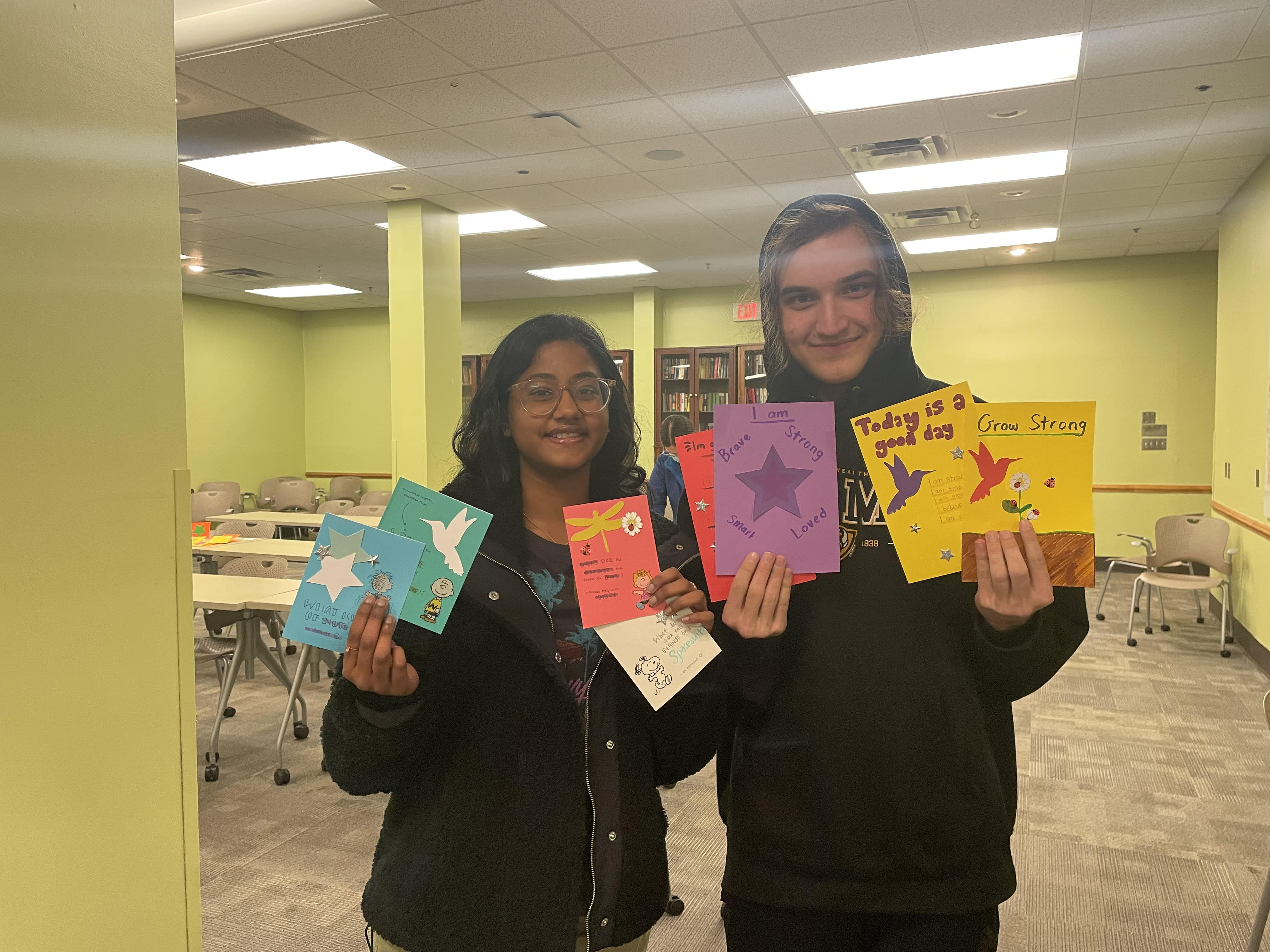 Two Honors students hold hand-made cards that were given to R P S students with incarcerated parents.