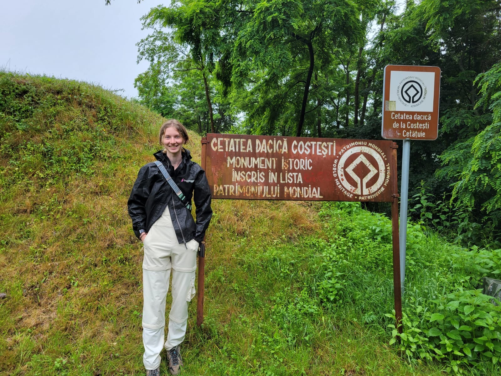 Jenna Hallinger stands next to a sign in Romania