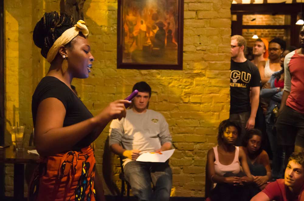 A student performs spoken word poetry at a local event